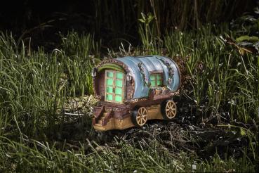 Preview: Ein kleines Feenhaus in Form eines Campingwagens beleuchtet im Garten